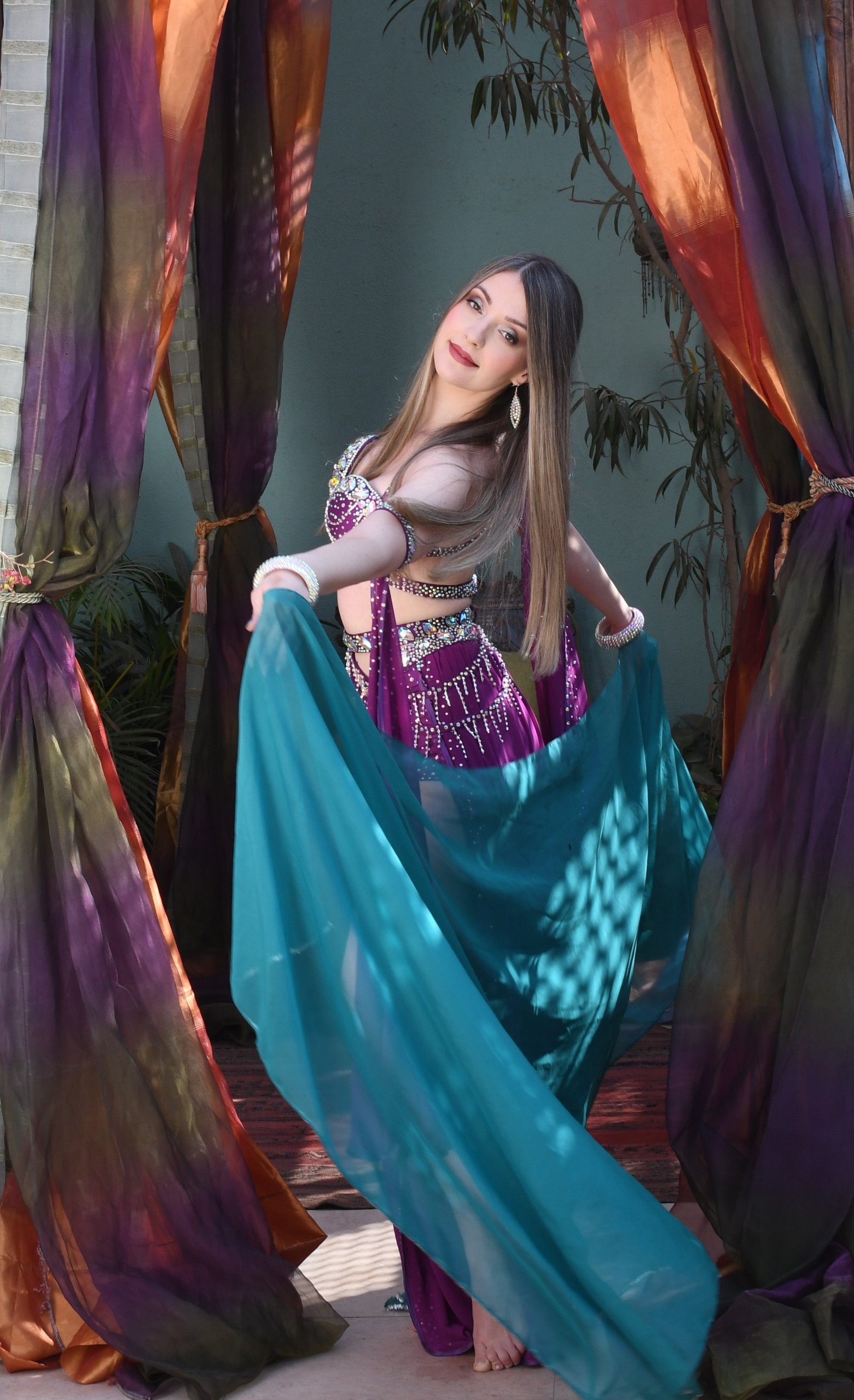 Belly dance Edinburgh teacher in a purple costume with a teal veil